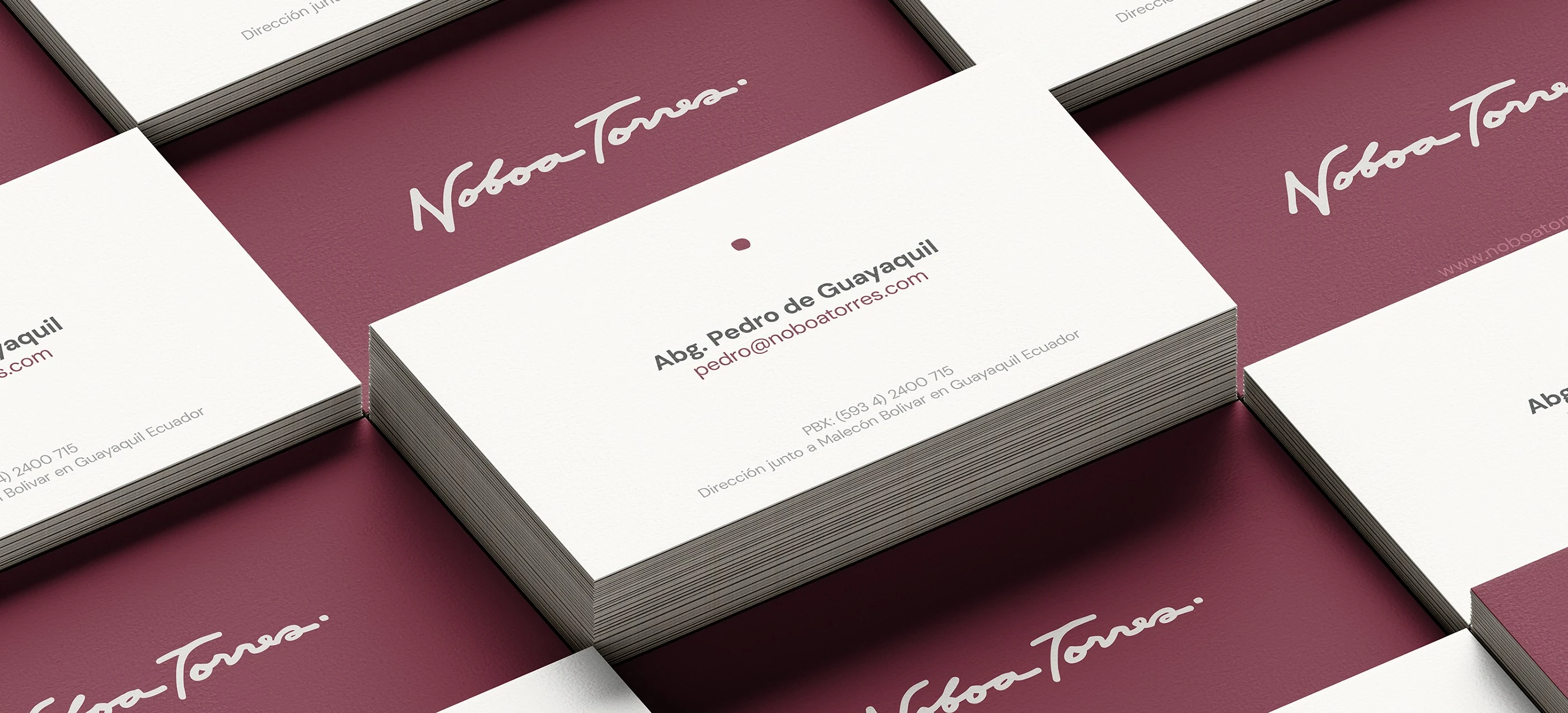 Noboa Torres business cards in wine and cream, showing the signature logo and a partner's contact details