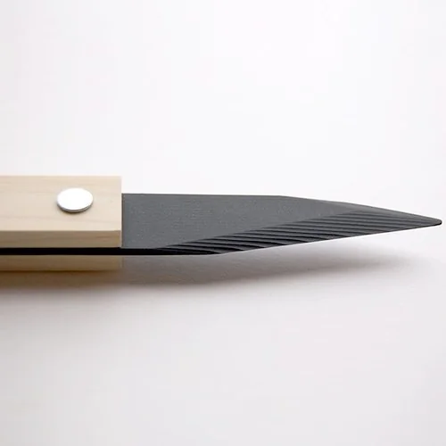 Moodboard reference: black blade set into a pale wood wall mount