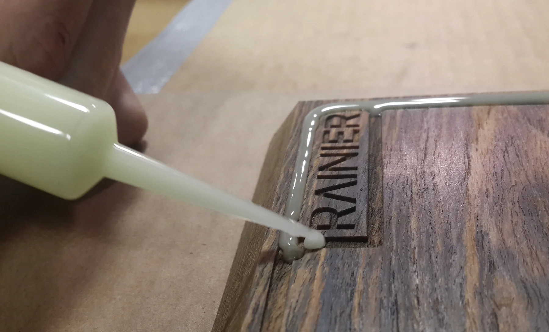 Glue applied to the metal Rainier logotype inlaid into the board's corner